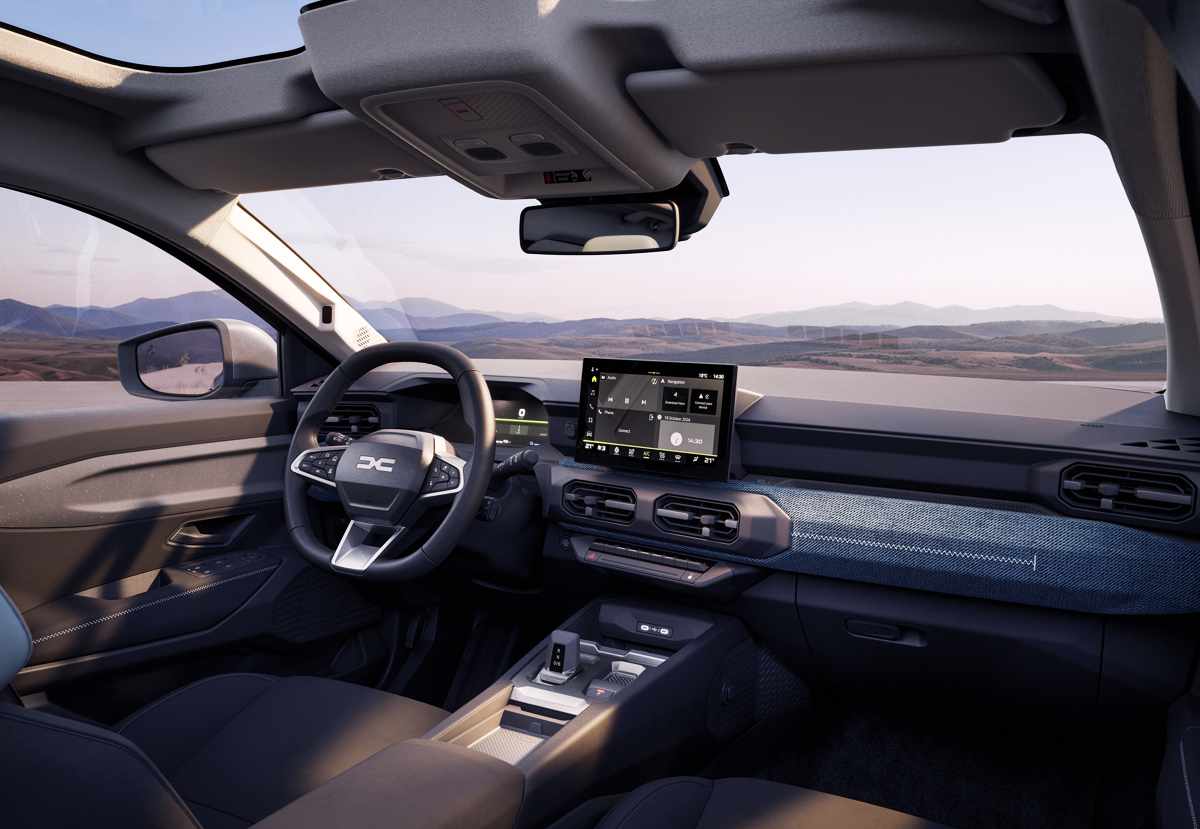 Interior de la nueva Dacia Striker desde la perspectiva del conductor, mostrando el volante multifunción, el cuadro de instrumentos digital y la pantalla central de 10,1 pulgadas.