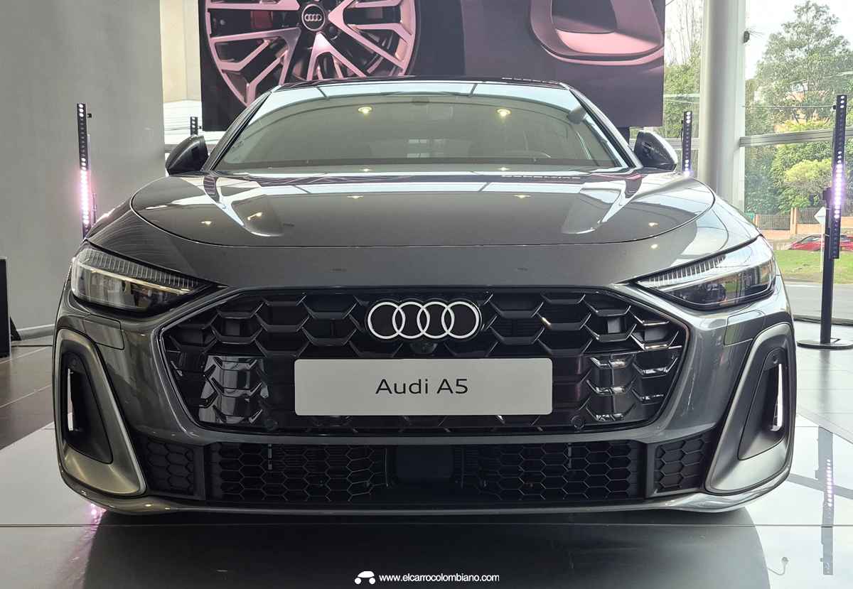 Toma frontal directa y agresiva del Audi A5 S Line, resaltando la gran parrilla deportiva negra con los cuatro aros y los ductos aerodinámicos con bordes plateados.