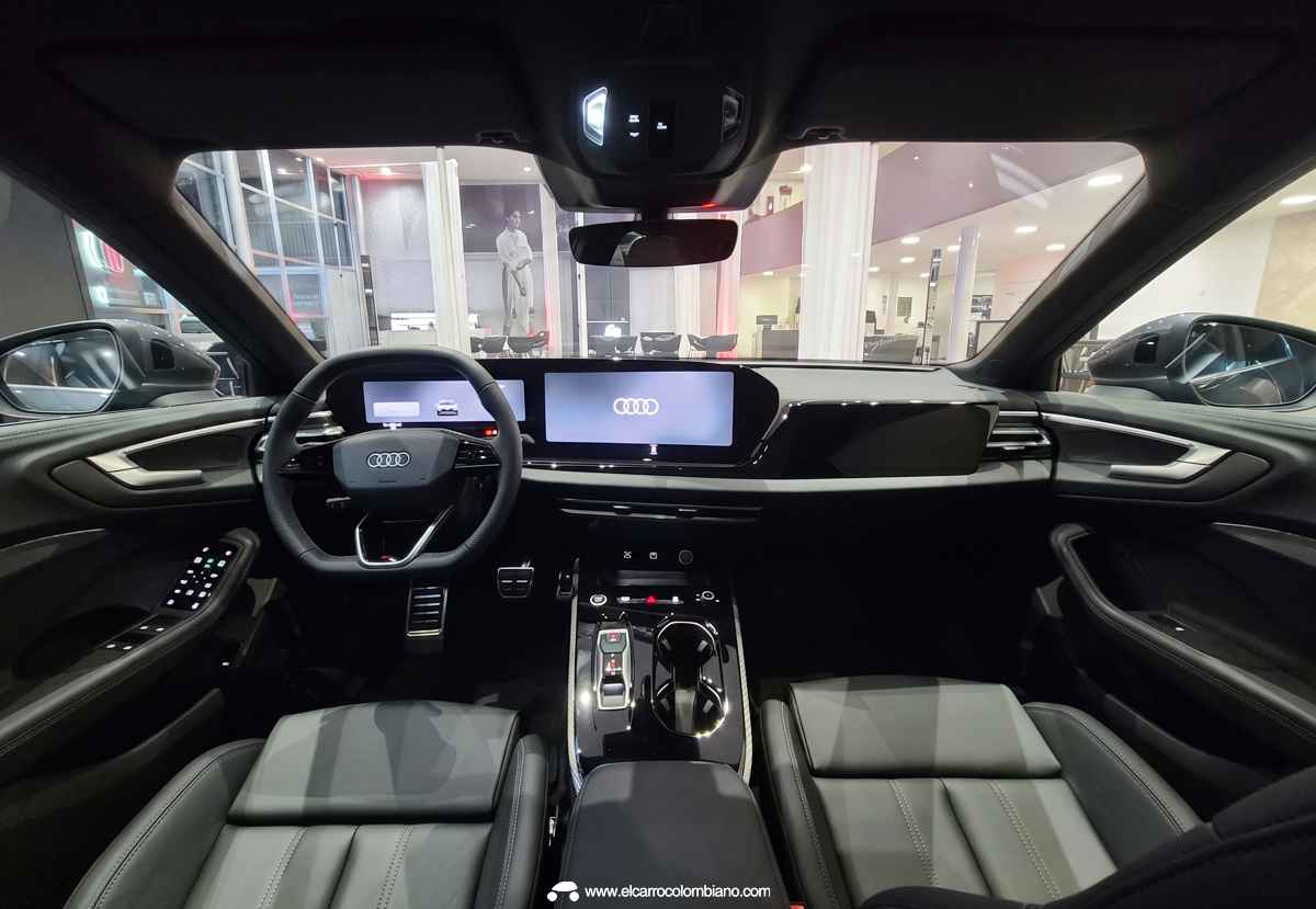 Vista general del avanzado habitáculo del nuevo Audi A5, detallando el panel digital de 11,9 pulgadas, la pantalla táctil OLED y la moldura de aluminio central.