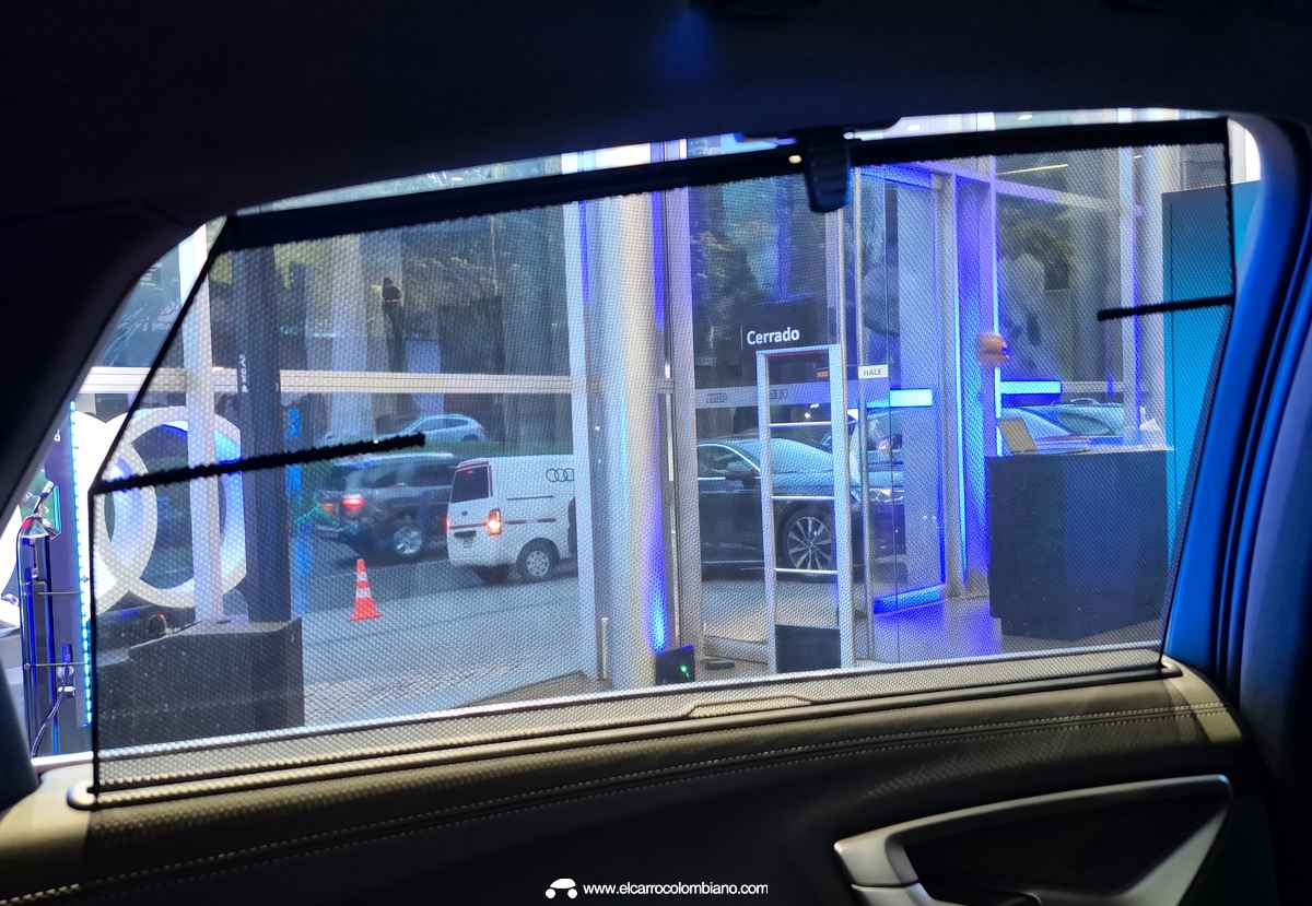 Detalle interior de la ventana trasera del Audi A5, mostrando la práctica cortinilla parasol desplegada para mejorar el confort térmico y visual de los pasajeros.