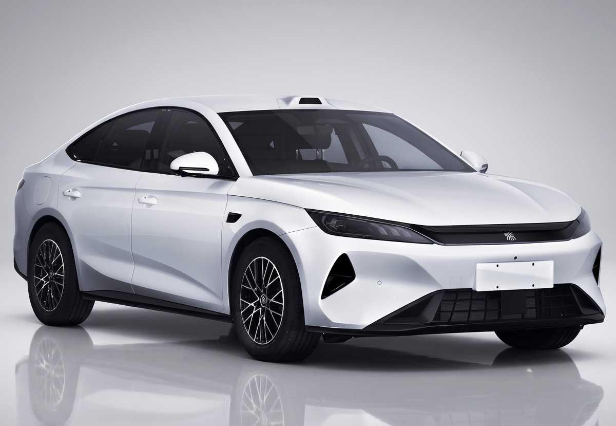 Plano delantero de tres cuartos del nuevo BYD Qin Plus color blanco, mostrando en detalle sus faros afilados, el elemento negro que los conecta y la línea de techo más tendida.