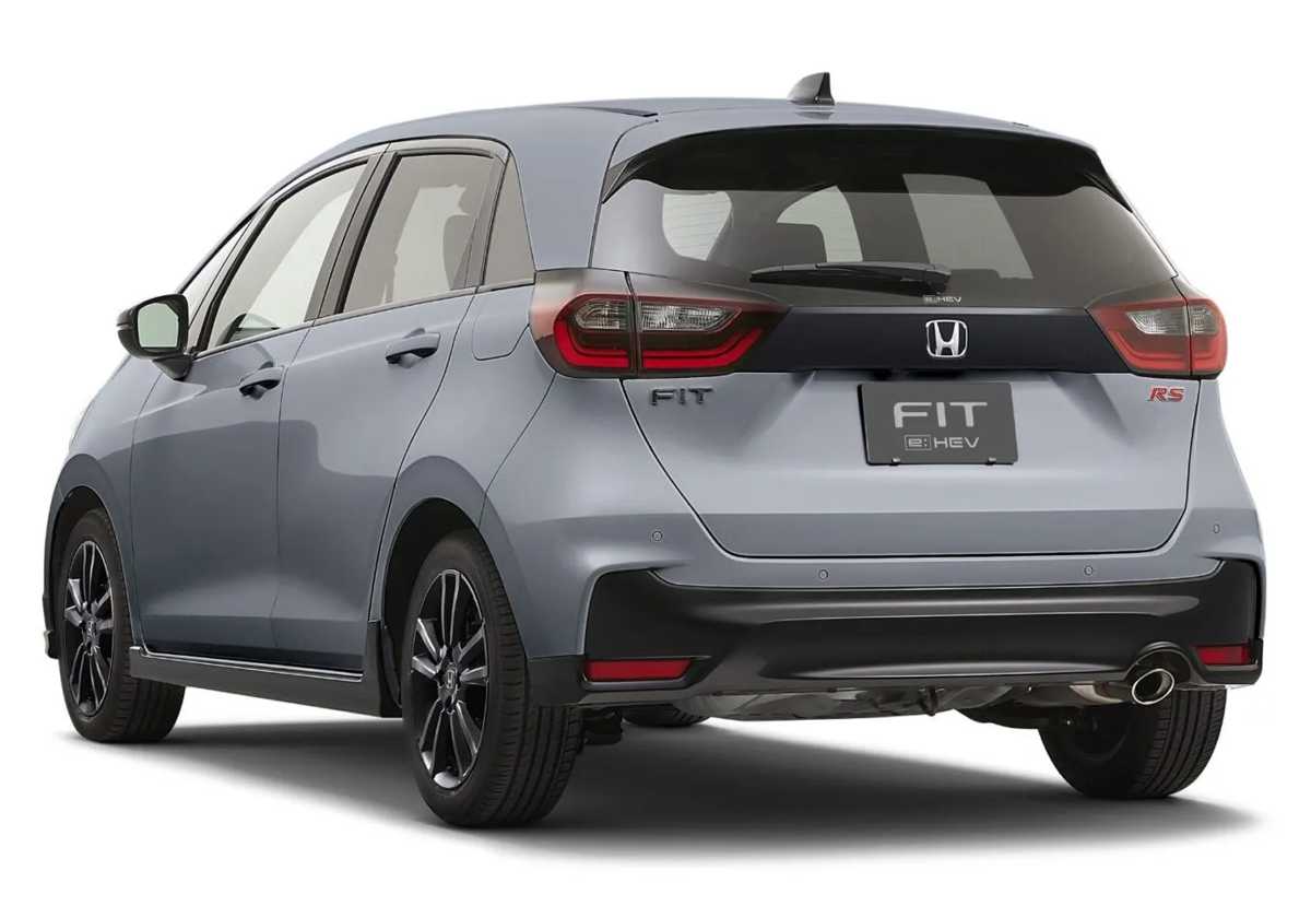 Vista trasera de tres cuartos del Honda Fit RS 2027 color gris, evidenciando el emblema e:HEV, el alerón superior oscuro y la salida de escape deportiva.