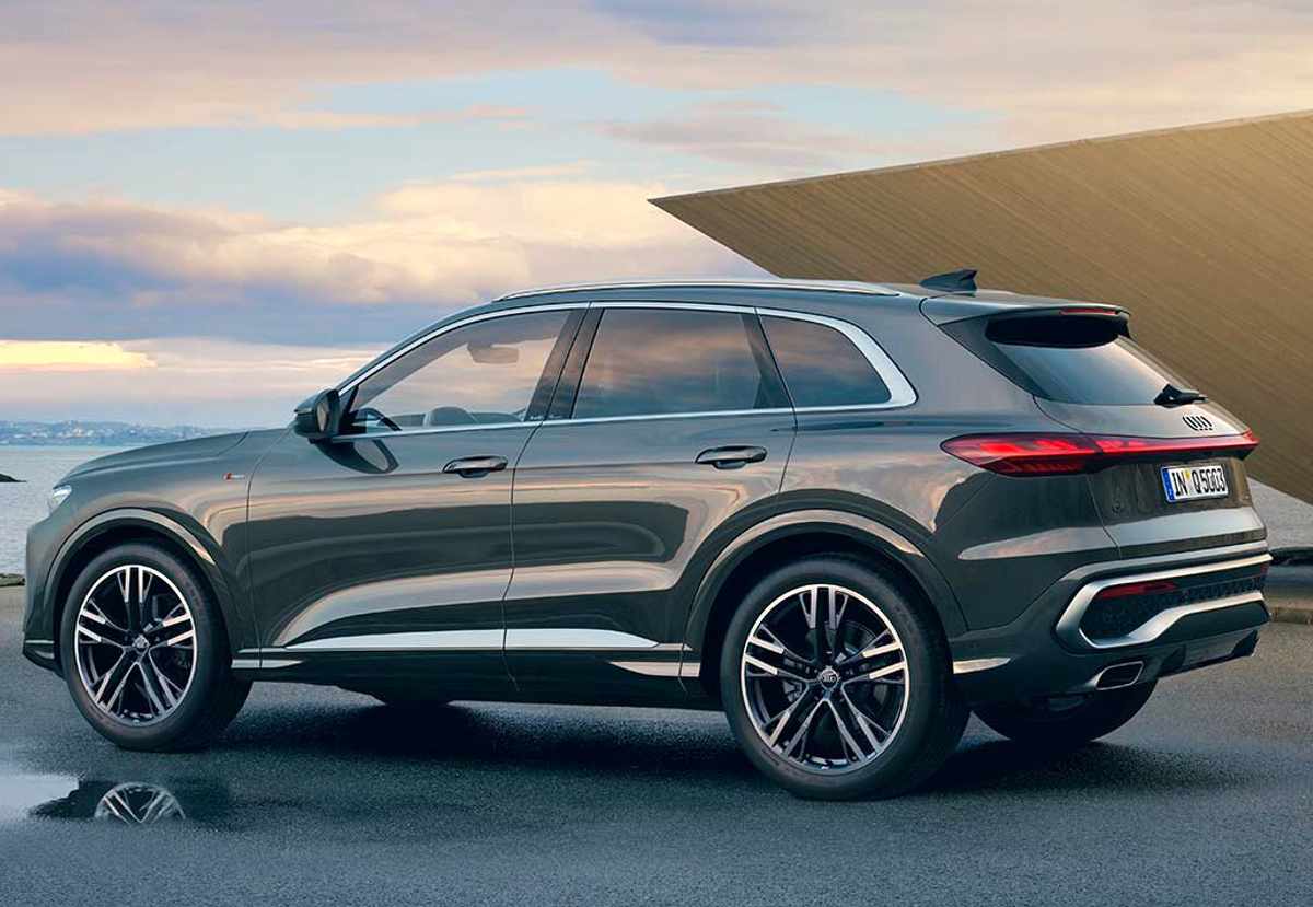 Perfil y vista trasera de la nueva Audi Q5 SUV color gris oscuro, resaltando su silueta tradicional orientada a la practicidad, rines de aleación y luces traseras unidas.