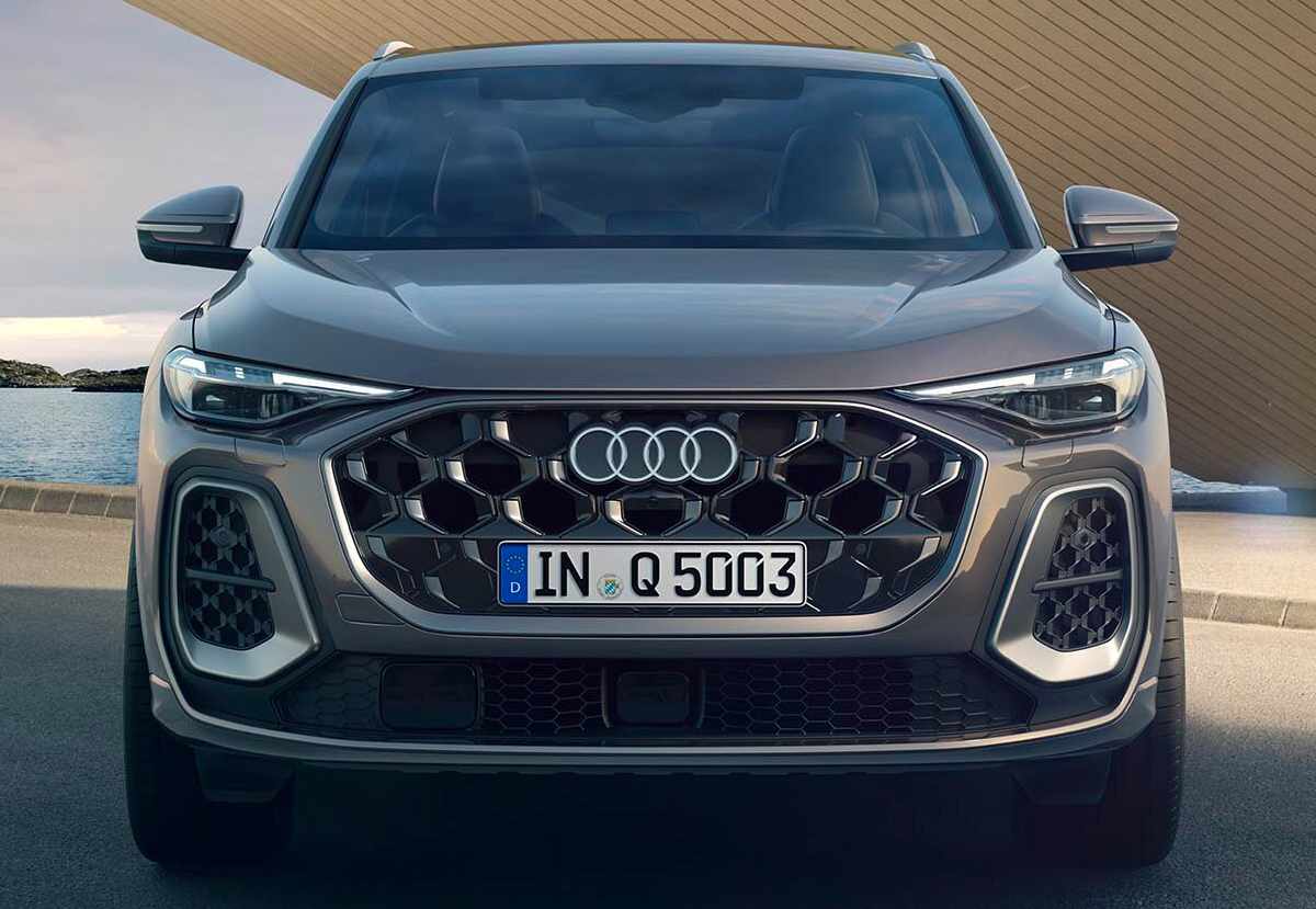 Plano frontal directo de la Audi Q5 SUV gris, detallando la imponente parrilla tipo panal de abejas, los faros Matrix LED delgados y las molduras inferiores plateadas.