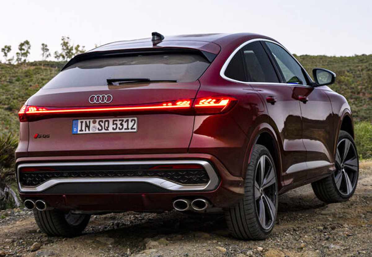 Plano trasero de tres cuartos de la poderosa Audi SQ5 Sportback color rojo cereza, evidenciando su marcada caída de techo fastback, difusor trasero prominente y cuatro salidas de escape reales.