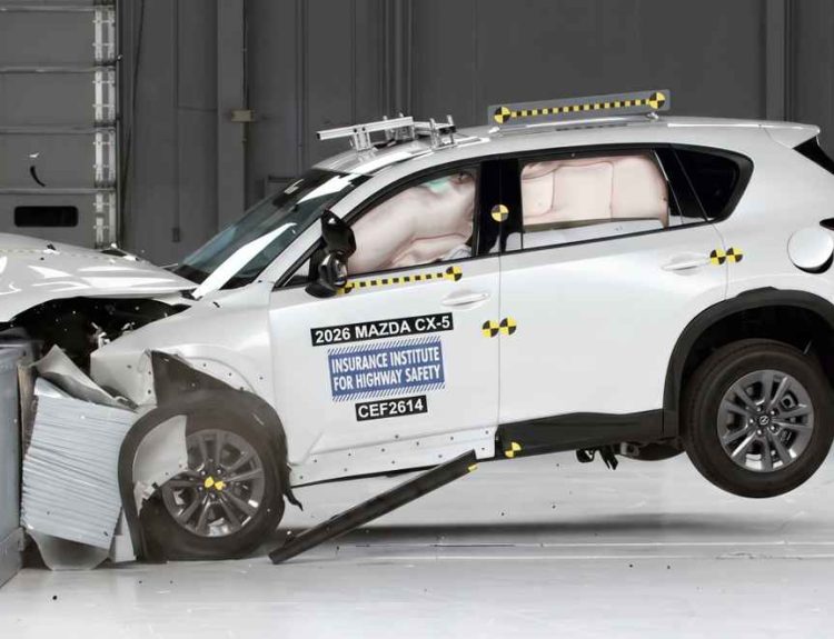 Momento exacto del impacto frontal con solapamiento de la nueva Mazda CX-5 blanca durante las exigentes pruebas de seguridad y choque del IIHS en laboratorio.