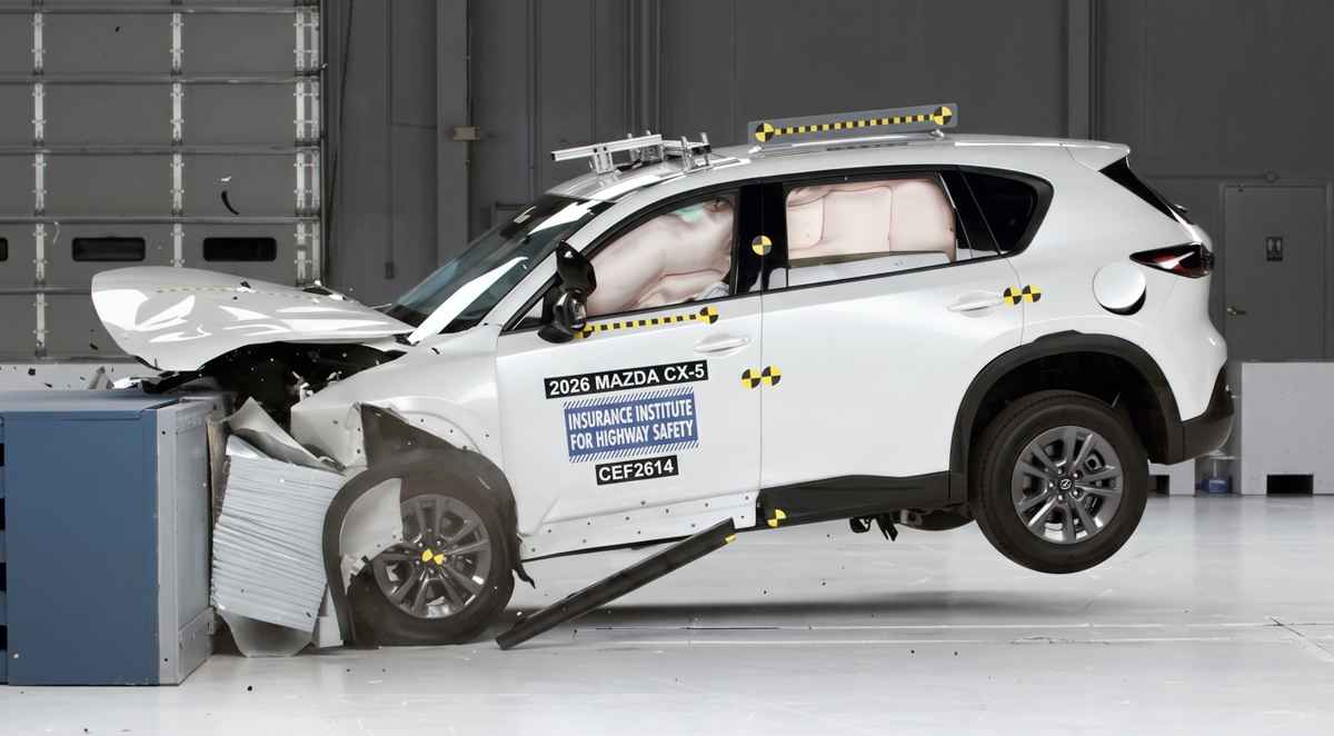 Momento exacto del impacto frontal con solapamiento de la nueva Mazda CX-5 blanca durante las exigentes pruebas de seguridad y choque del IIHS en laboratorio.