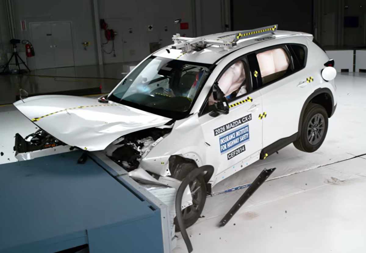 Ángulo lateral de la prueba de choque frontal de la Mazda CX-5 2026 en el laboratorio del IIHS, demostrando la resistencia de su pilar A y la rápida activación de los airbags de cortina.
