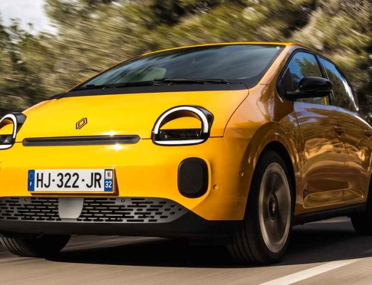 Vista frontal dinámica del nuevo Renault Twingo E-Tech eléctrico color amarillo circulando por una carretera, demostrando su agilidad durante las pruebas de manejo en Europa.