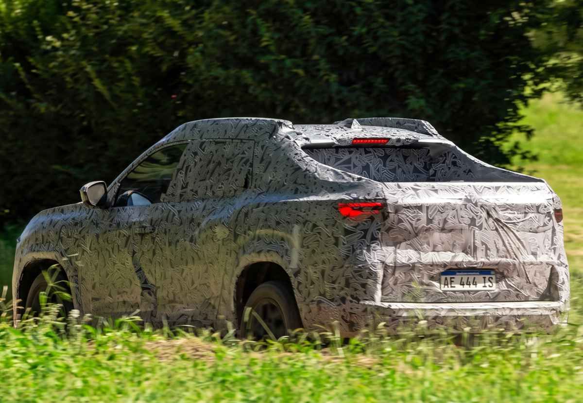 Vista trasera de la pick-up Renault Niágara en fase de pruebas dinámicas, mostrando la silueta robusta de su platón y la firma lumínica LED de sus faros traseros en desarrollo.