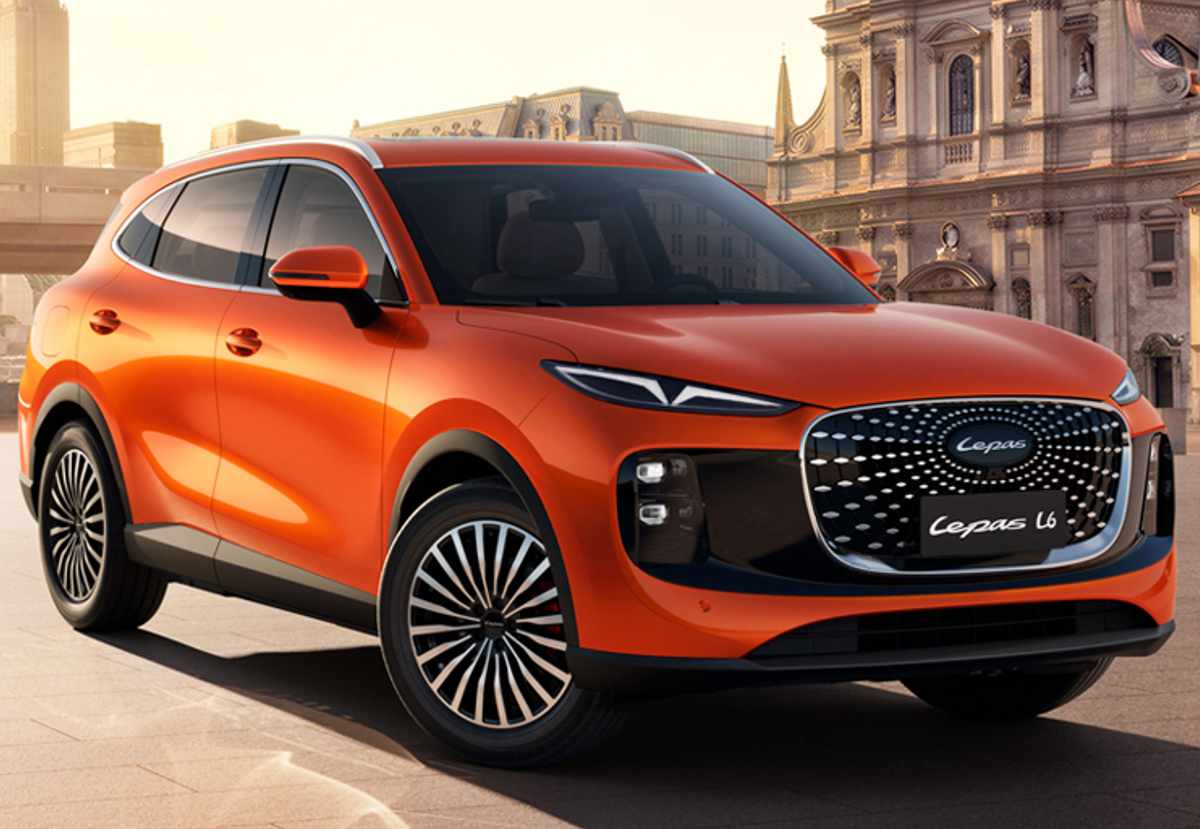 Vista frontal panorámica del SUV híbrido enchufable Lepas L6 en color naranja vibrante, luciendo su imponente parrilla tipo diamante en un entorno urbano clásico.