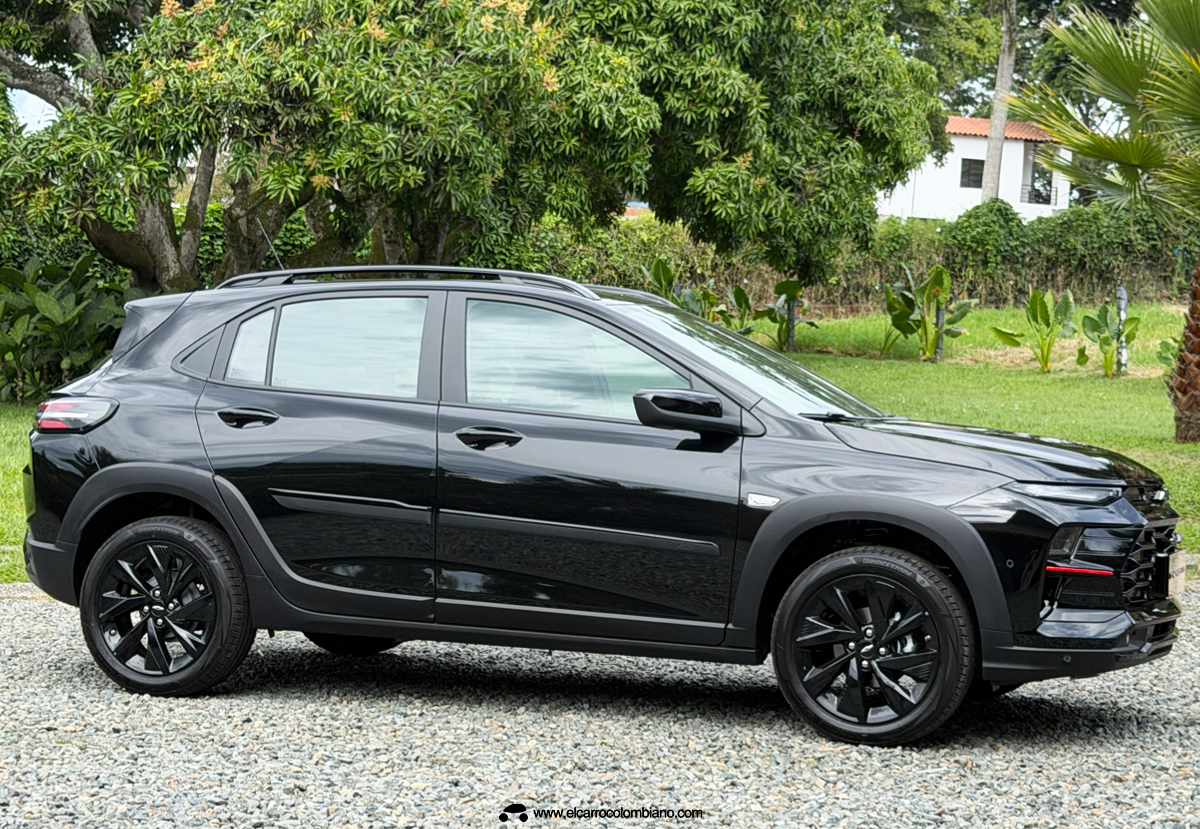 Perfil lateral del Chevrolet Sonic RS en color negro, exhibiendo sus rines oscurecidos de 17 pulgadas, molduras plásticas en los pasos de rueda y rieles de techo.