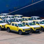 Primer lote de camionetas Nissan Frontier Pro estacionadas en el puerto de Shanghái frente al barco de carga, iniciando su viaje de exportación a Latinoamérica.