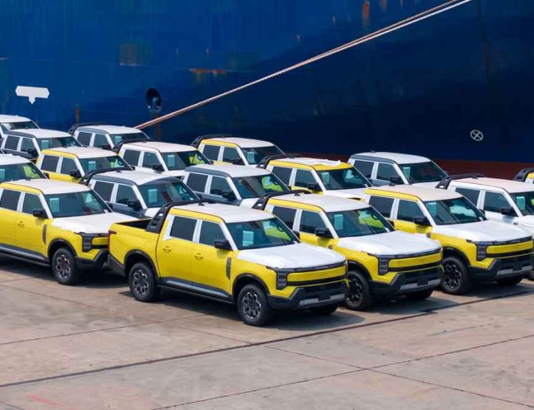 Primer lote de camionetas Nissan Frontier Pro estacionadas en el puerto de Shanghái frente al barco de carga, iniciando su viaje de exportación a Latinoamérica.
