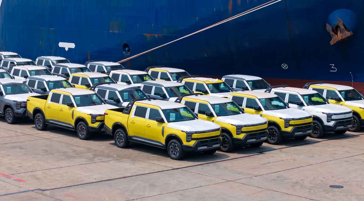 Primer lote de camionetas Nissan Frontier Pro estacionadas en el puerto de Shanghái frente al barco de carga, iniciando su viaje de exportación a Latinoamérica.