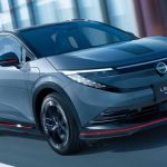 Vista frontal en movimiento del nuevo crossover eléctrico Nissan Leaf Nismo en color Stealth Gray, destacando su parachoques aerodinámico y el característico acento rojo inferior.
