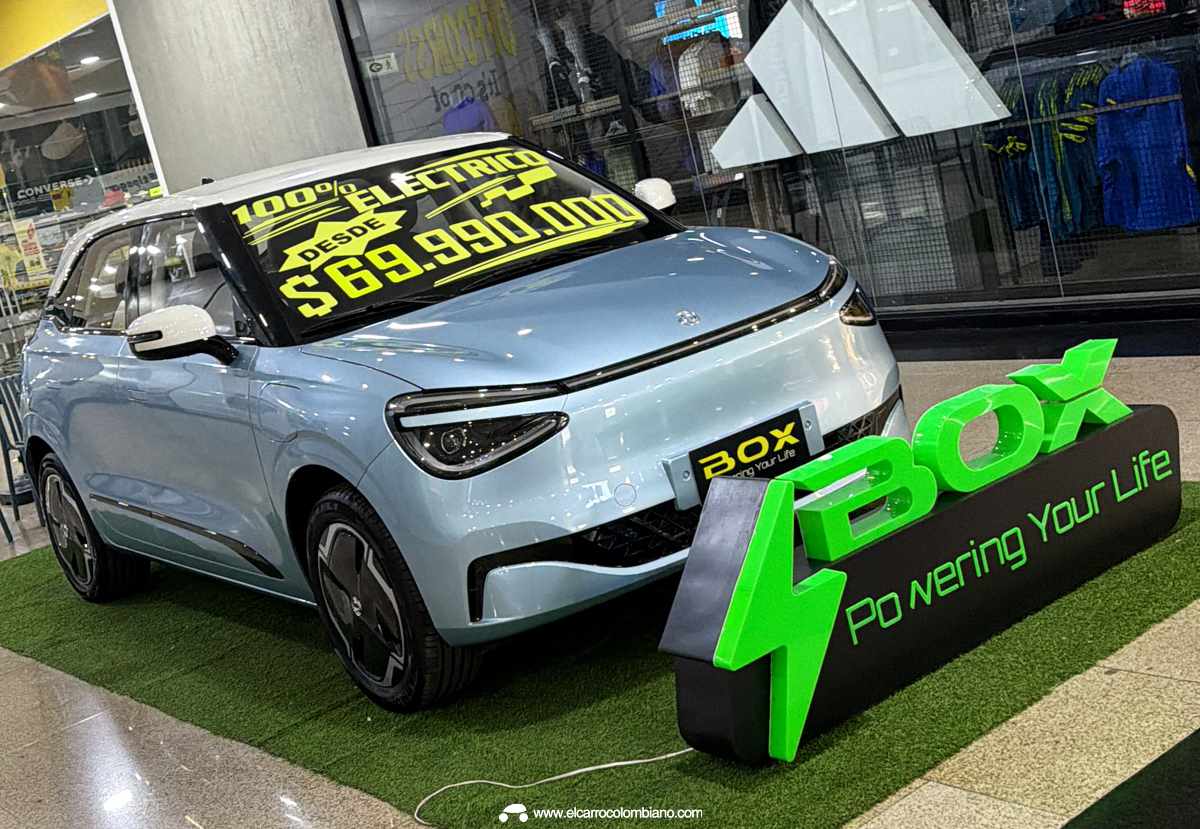 Unidad del Dongfeng Box azul exhibida en un centro comercial de Colombia con un gran letrero anunciando su nuevo precio desde 69.990.000 pesos.