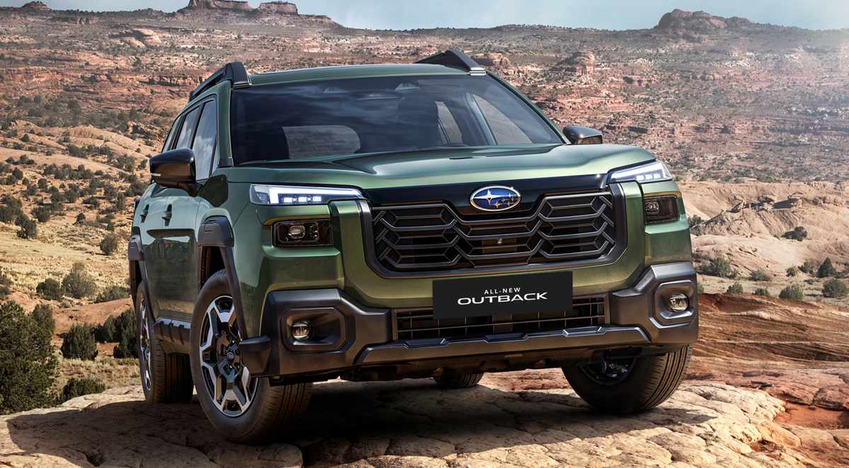 Vista frontal de tres cuartos de la nueva Subaru Outback 2026 en color verde, exhibiendo su agresivo diseño frontal de SUV sobre un terreno rocoso.