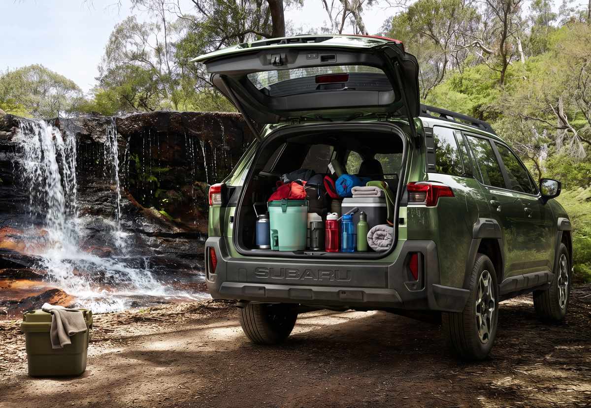 Baúl de la Subaru Outback 2026 abierto y totalmente cargado con equipo de campamento frente a una cascada, demostrando sus 530 litros de capacidad.