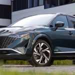 Vista frontal de tres cuartos de la Nissan Qashqai e-Power en color verde oscuro, destacando su renovada parrilla ancha y diseño híbrido aerodinámico.
