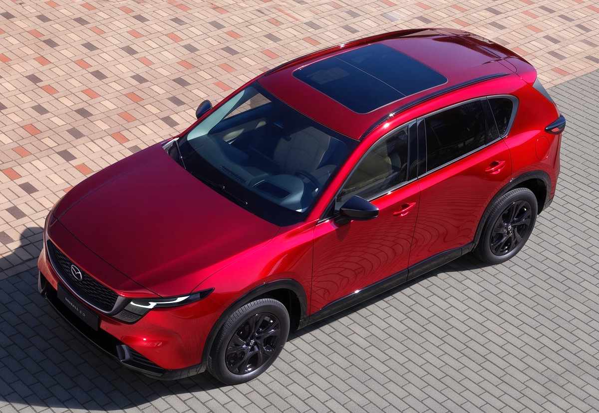 Vista superior de una SUV Mazda CX-5 2026 en color rojo vibrante con techo panorámico, mostrando el lenguaje de diseño elegante de la nueva era híbrida del fabricante.
