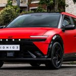Vista frontal de tres cuartos del nuevo Hyundai Ioniq 3 N Line en color rojo mate con detalles negros, destacando su franja LED pixelada y diseño aerodinámico.