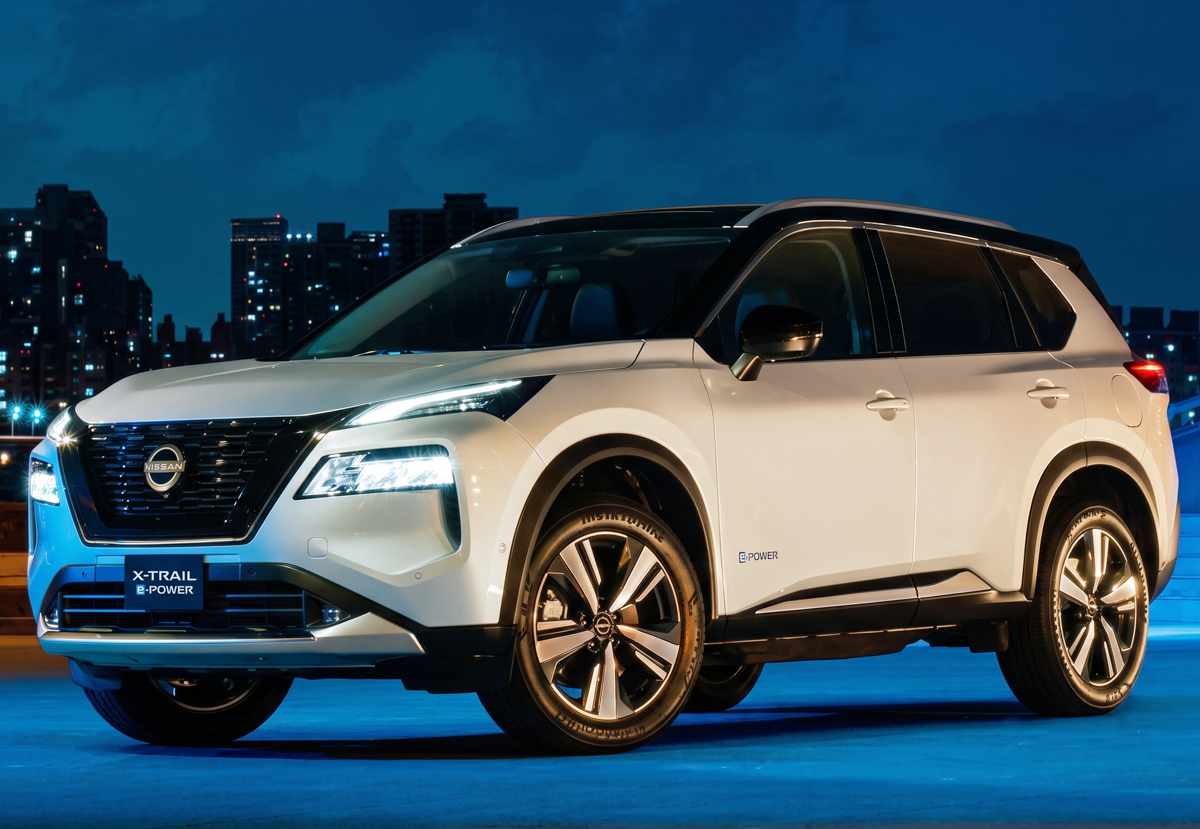 Camioneta Nissan X-Trail e-Power de color blanco exhibida en un entorno urbano nocturno, destacando entre las SUV electrificadas más populares del mercado nacional.