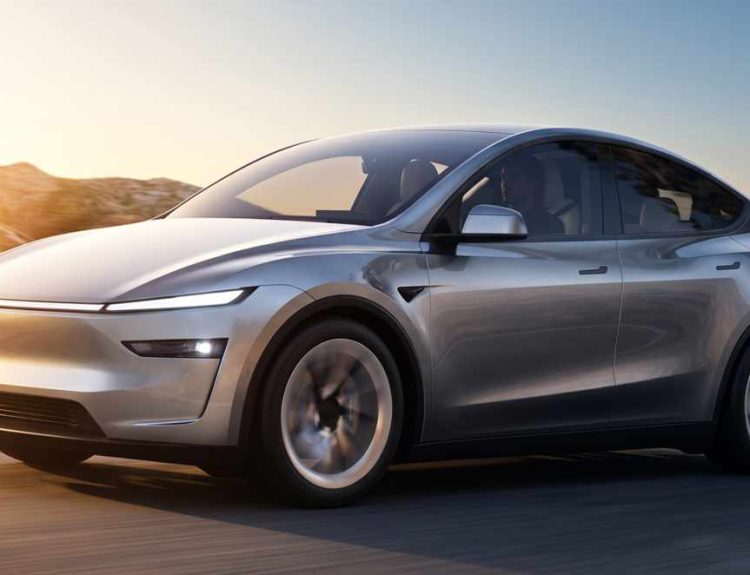 Vehículo eléctrico Tesla Model Y color plata en movimiento por una carretera al atardecer, destacando como el carro más vendido de Colombia en 2026.