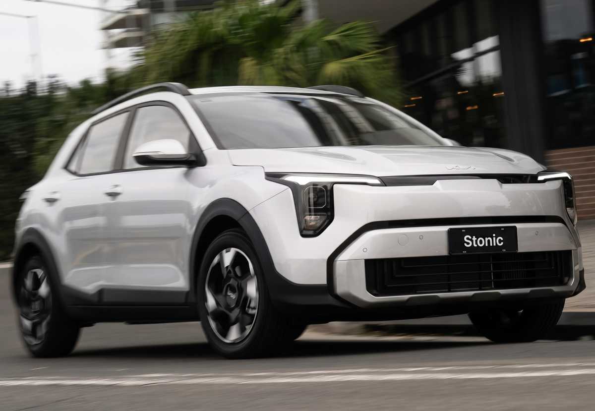 Crossover Kia Stonic color blanco en movimiento por una vía urbana, modelo híbrido que impulsó fuertemente las ventas de la marca coreana en Colombia.