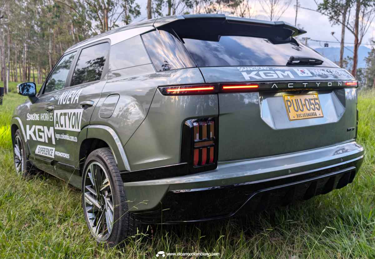 Diseño posterior de la camioneta KGM Actyon resaltando su firma lumínica LED extendida y su robusto parachoques durante la prueba de ruta en carreteras colombianas.