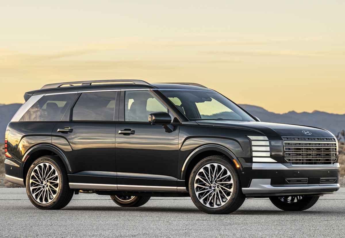 Vista de tres cuartos de la Hyundai Palisade Híbrida color negro al atardecer, mostrando sus rines bitono de 20 pulgadas y carrocería de proporciones cuadradas y robustas.
