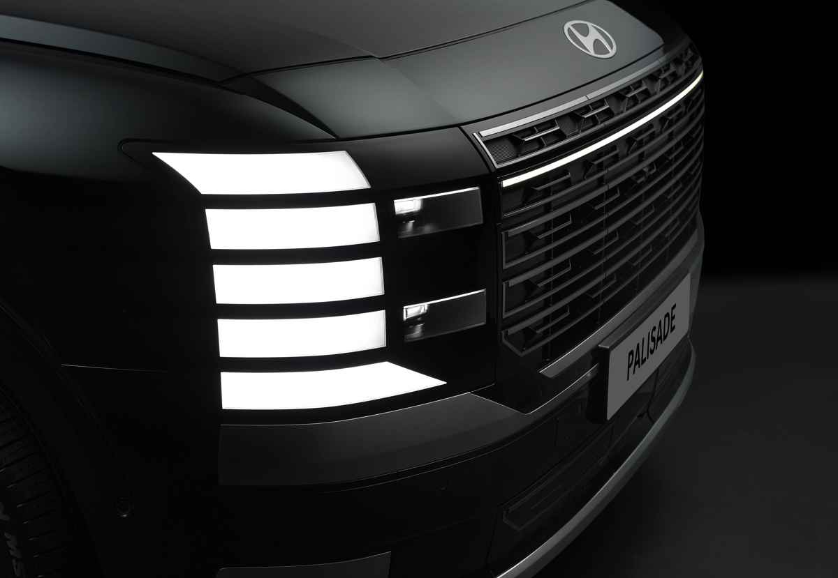 Acercamiento a las imponentes luces diurnas LED segmentadas y faros principales integrados sutilmente en la parrilla frontal de la nueva Hyundai Palisade Híbrida.