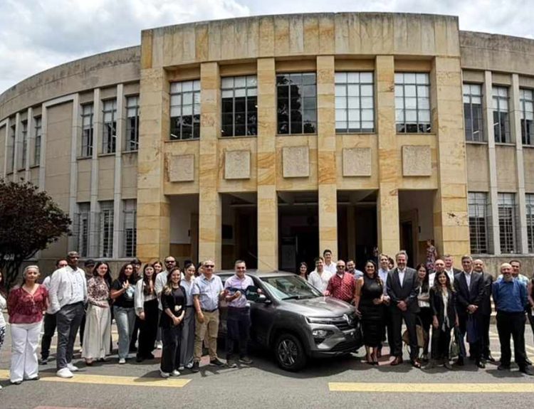 Numeroso grupo de estudiantes y directivos posando junto al Renault Kwid gris donado por Sofasa, frente a la imponente fachada de la Facultad de Minas de la Universidad Nacional.