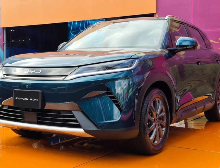Camioneta SUV BYD Yuan Up DM-i híbrida enchufable color azul oscuro, exhibida sobre una llamativa plataforma naranja durante su lanzamiento oficial en el BYD Fest en Bogotá.