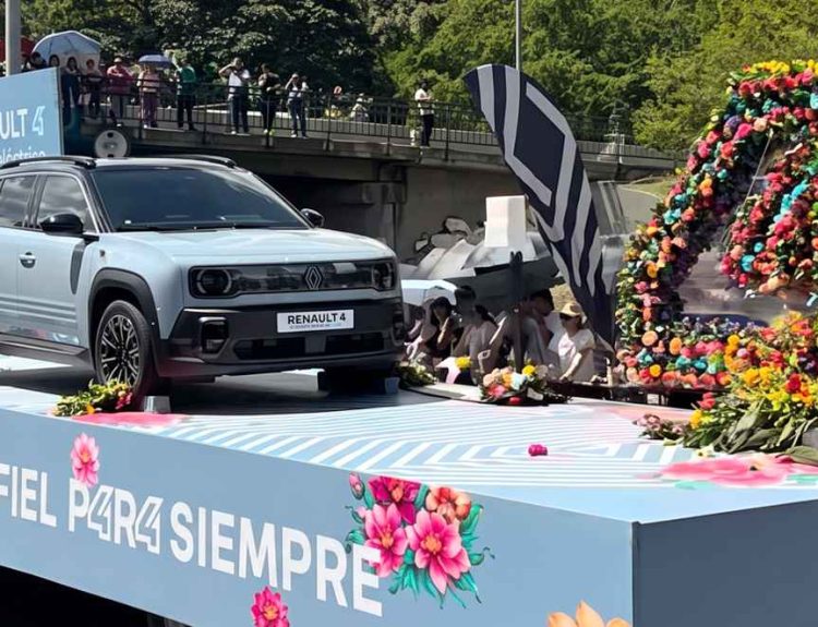 Nuevo Renault 4 E-Tech eléctrico color azul exhibido sobre una plataforma rodante decorada con flores y el mensaje 'Amigo Fiel P4R4 Siempre' durante el desfile en Medellín.