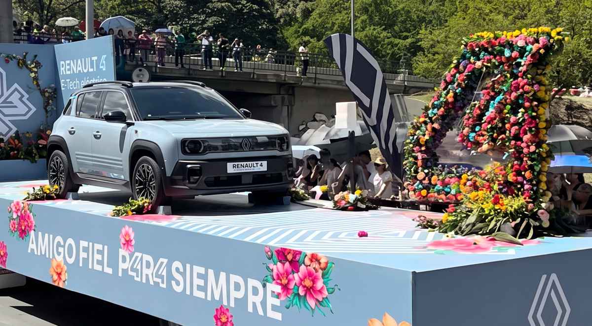 Nuevo Renault 4 E-Tech eléctrico color azul exhibido sobre una plataforma rodante decorada con flores y el mensaje 'Amigo Fiel P4R4 Siempre' durante el desfile en Medellín.
