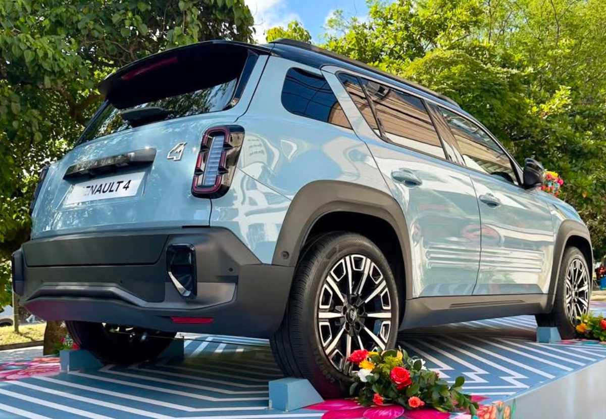 Diseño posterior de la SUV Renault 4 eléctrica exhibida al aire libre en Medellín, destacando sus luces traseras en forma de cápsula y su baúl rodeado de decoración floral.
