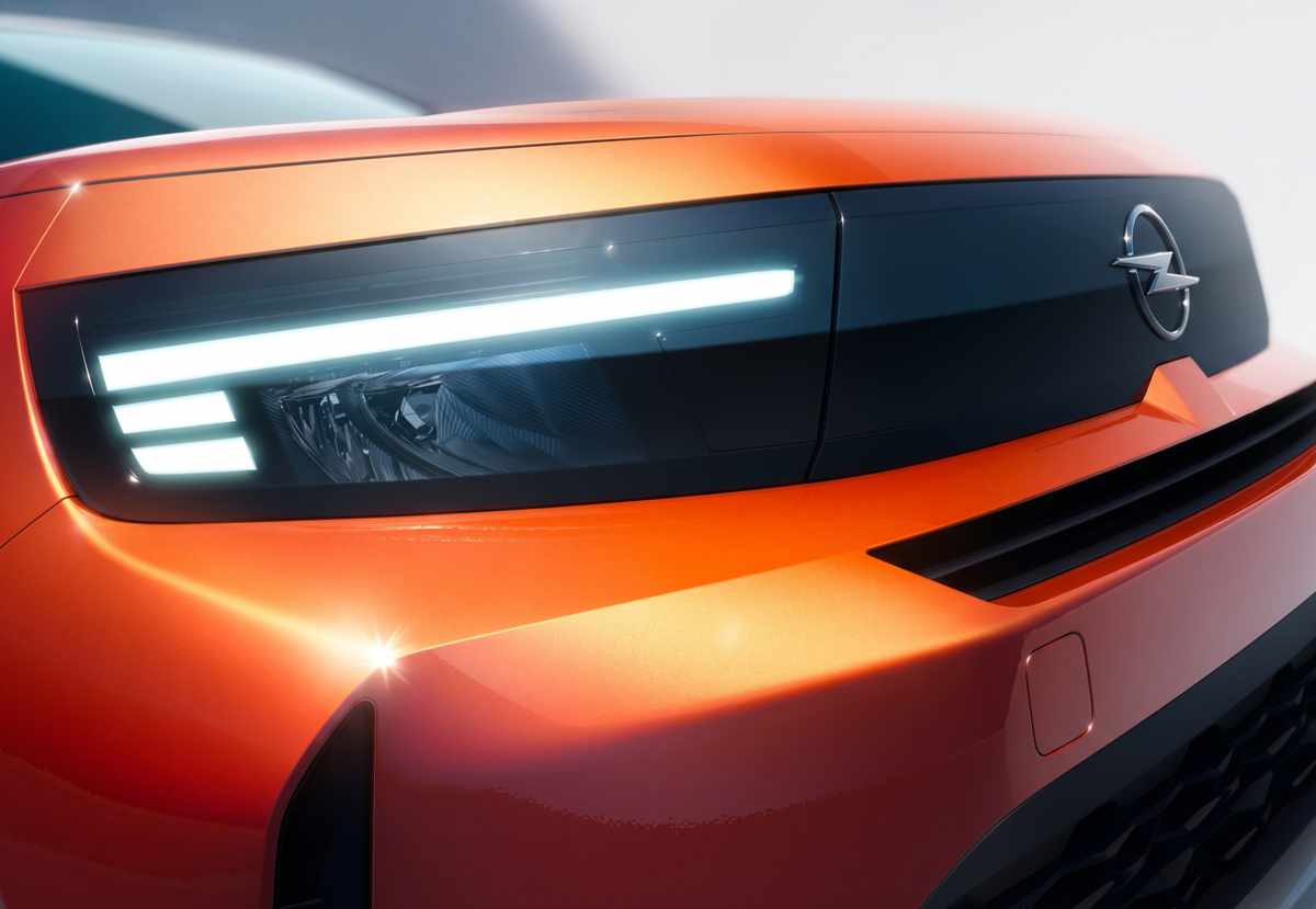 Toma macro del faro delantero LED y la parrilla Vizor en una Opel Crossland color naranja cobre, enfocándose en la firma lumínica en forma de 'L' invertida.