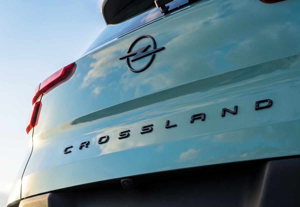 Detalle de la sección trasera en la Opel Crossland Híbrida color verde metalizado, mostrando las letras del modelo en relieve y la cámara de reversa integrada.
