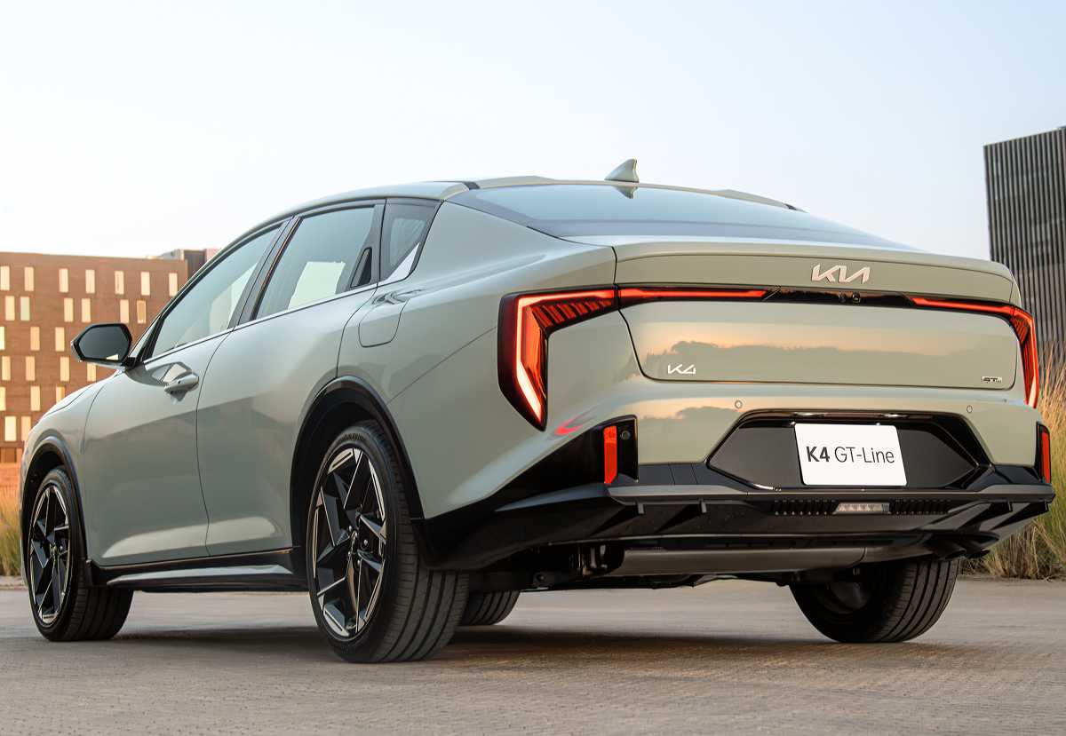 Diseño posterior del sedán Kia K4 GT-Line, resaltando la pronunciada caída del techo y las distintivas luces LED continuas que forman un arco de lado a lado.