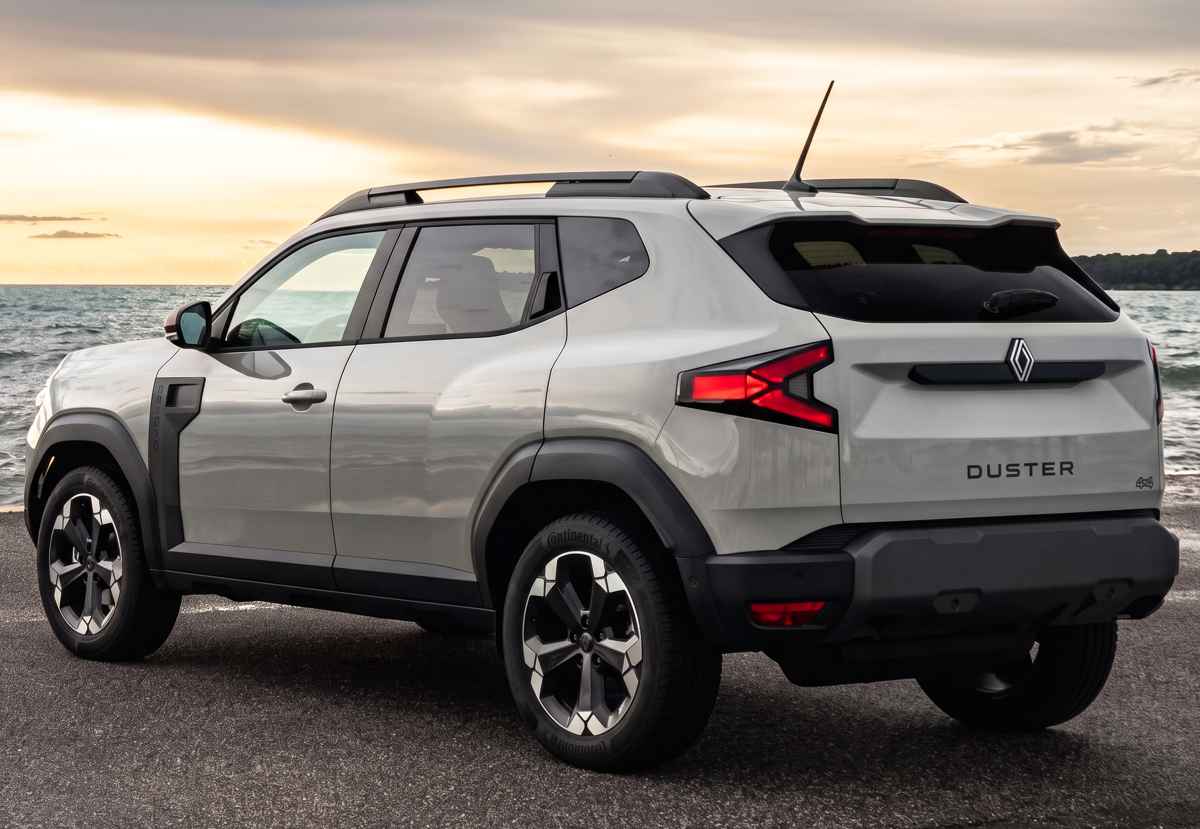 Diseño posterior de la nueva Renault Duster E-Tech e-4WD estacionada junto al mar, resaltando sus distintivas luces traseras LED en forma de 'Y' y el emblema Duster en el portón.