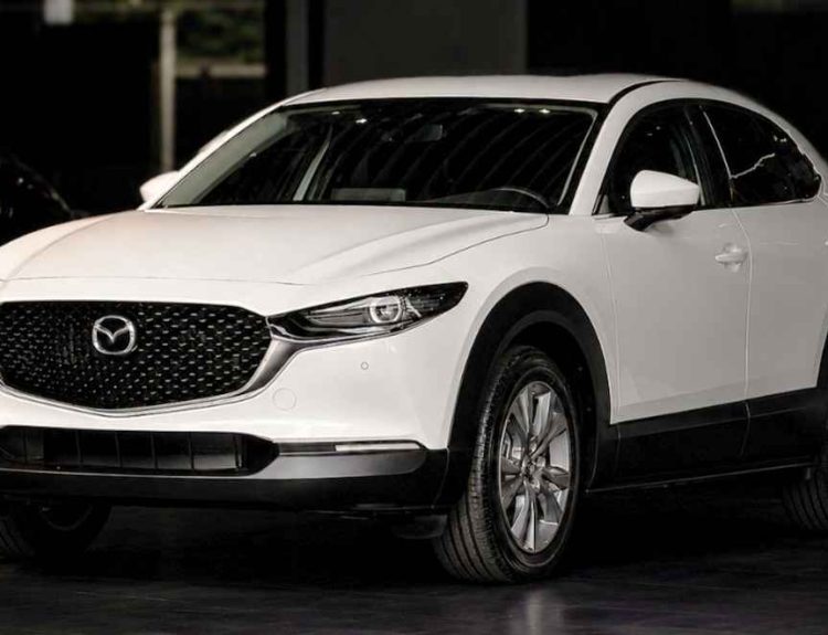 Vista frontal de tres cuartos de una Mazda CX-30 color blanco exhibida en el concesionario Madiautos, modelo que lidera los beneficios para estrenar carros Mazda en Colombia.