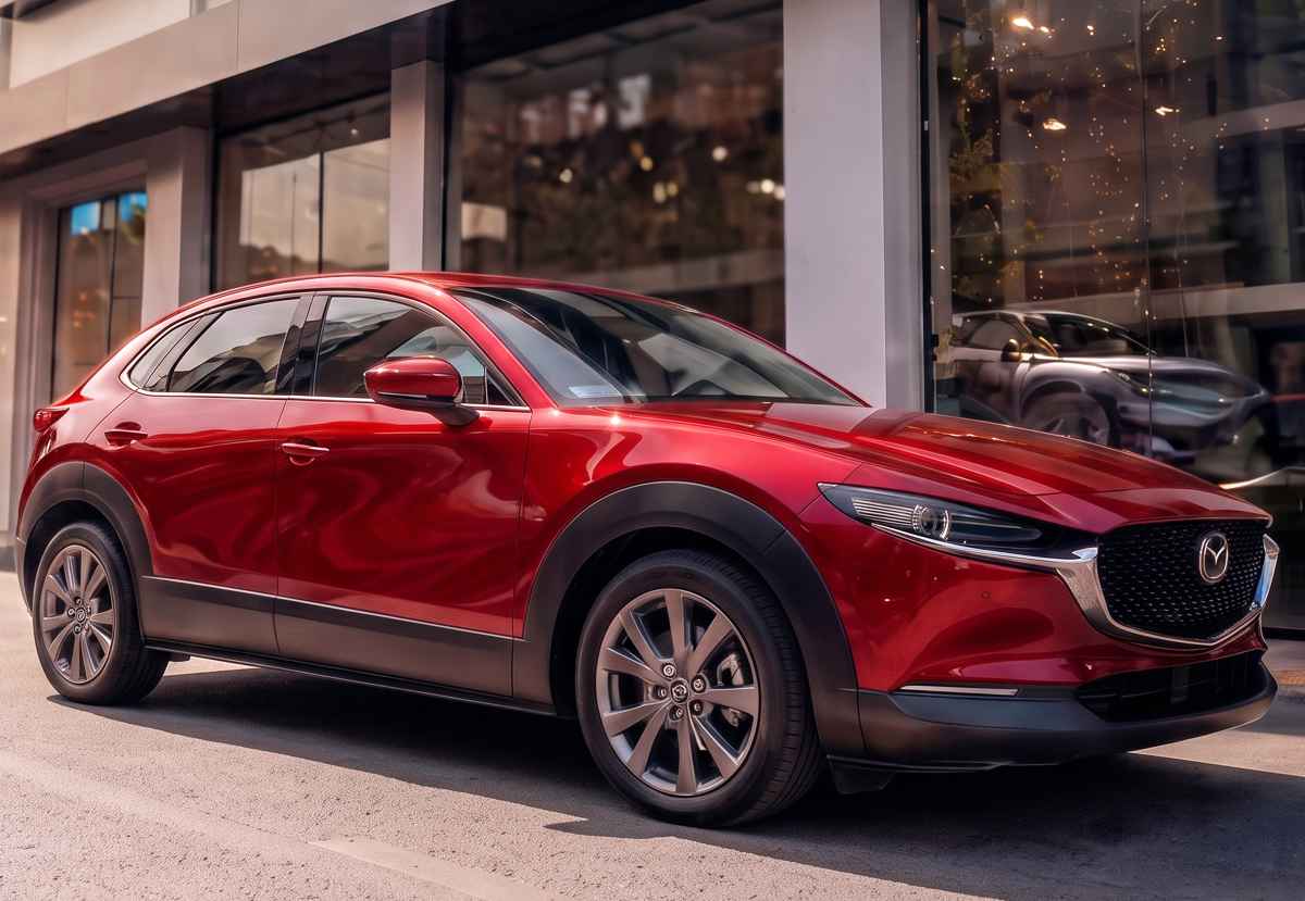 Elegante Mazda CX-30 color Rojo Diamante estacionada a las afueras del concesionario Madiautos, destacando su diseño SUV urbano y su disponibilidad para entrega inmediata.