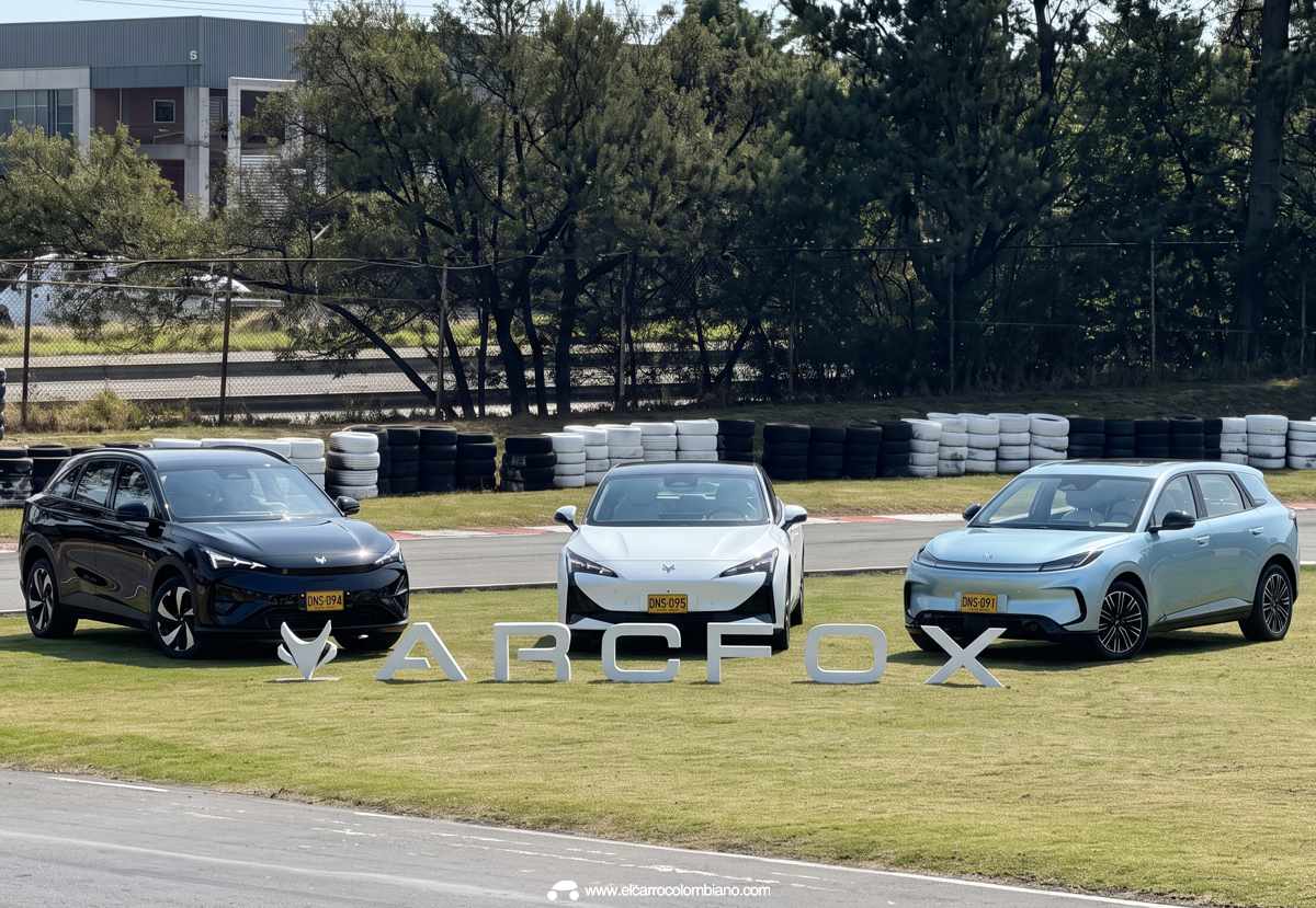 Plano general de los tres carros eléctricos Arcfox T1, S5 y T5 estacionados sobre una pista de pruebas, destacando las letras gigantes de la marca en primer plano.