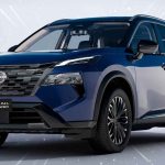 Plano frontal de tres cuartos de la renovada Nissan X-Trail e-Power 2027 color azul sobre fondo claro, destacando su nueva parrilla ancha y diseño frontal.