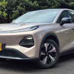Plano frontal de tres cuartos de la SUV eléctrica Changan Nevo Q05 color plata estacionada sobre asfalto, destacando su delgada franja de luces diurnas LED.