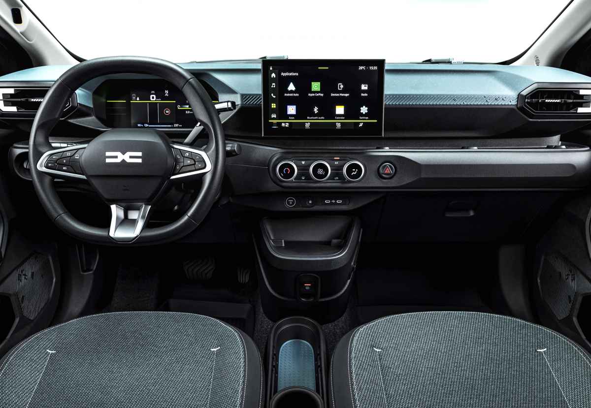 Plano general del interior delantero del nuevo Dacia Spring, enfocándose en el nuevo volante con el logo DC, el cuadro digital de 7 pulgadas y la pantalla central táctil de 10,1 pulgadas.