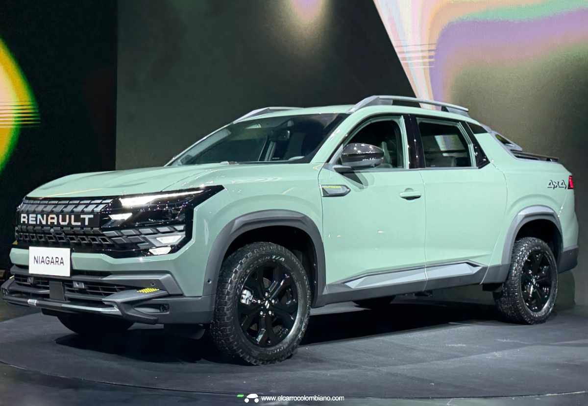 Plano frontal de tres cuartos de la pick-up Renault Niagara color verde claro sobre el escenario de su lanzamiento mundial, exhibiendo su imponente diseño frontal y rines negros.