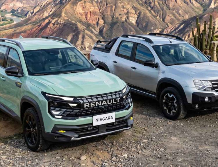 Plano frontal de tres cuartos de la nueva Renault Niagara color verde junto a una Renault Oroch color plata estacionadas en un paisaje montañoso, comparando directamente sus diseños.