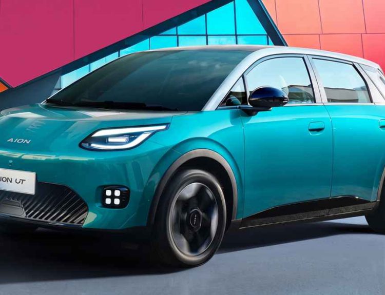 Plano frontal de tres cuartos del carro eléctrico GAC Aion UT color turquesa frente a un fondo geométrico colorido, destacando sus faros ovalados y rines oscuros de 17 pulgadas.